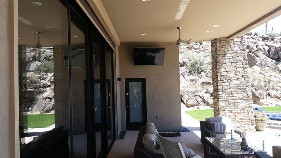 Covered patio living area with an outdoor-rated display and desert mountain view