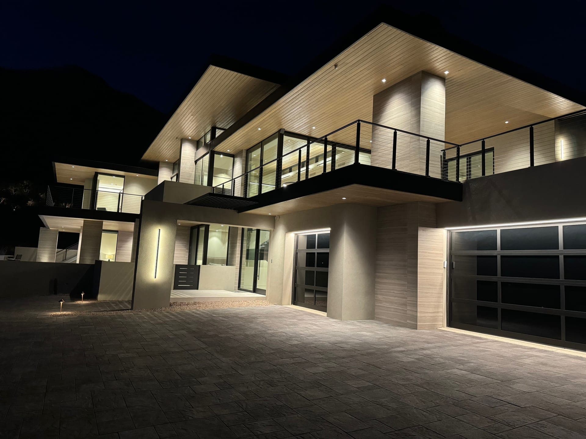 Two-storey modern facade illuminated at night with integrated exterior lighting