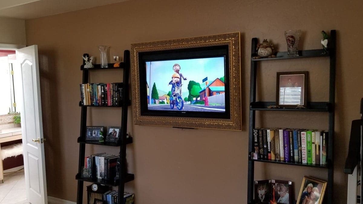 Family room with ladder shelving flanking a wall-mounted television