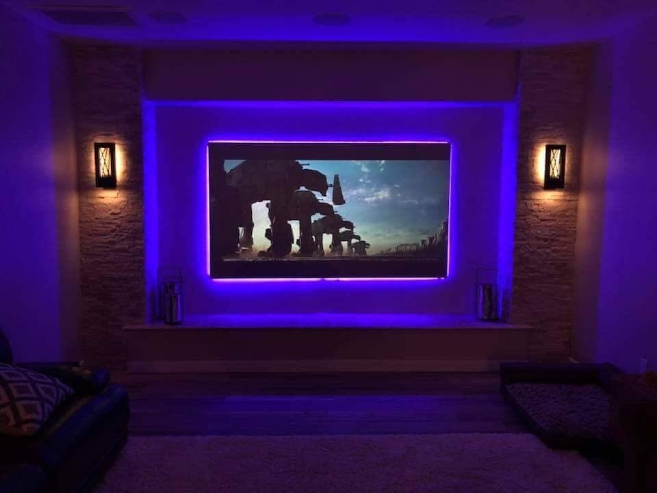 Home theater with purple LED cove lighting framing the screen