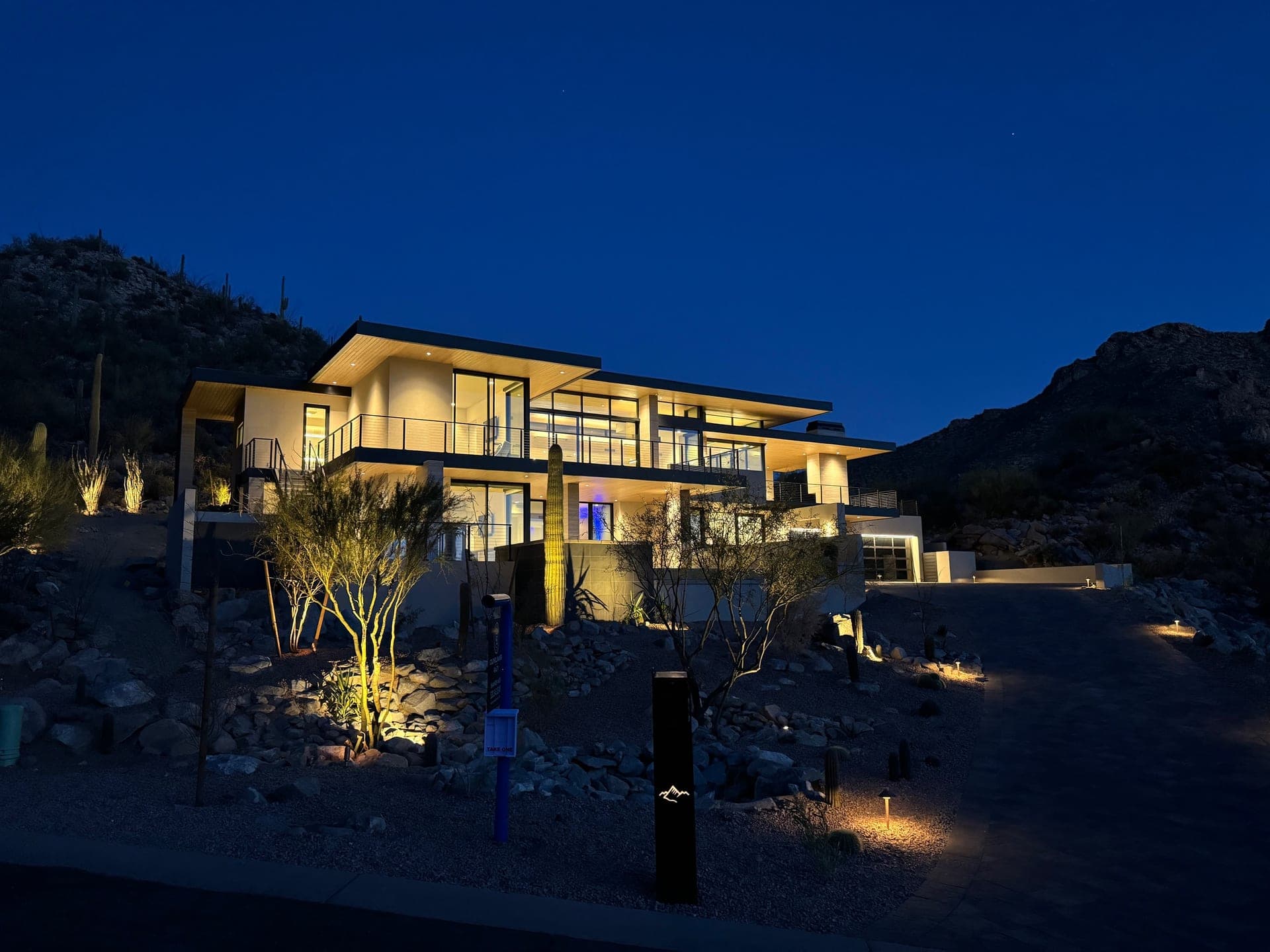Desert home at night with automated landscape and pathway lighting