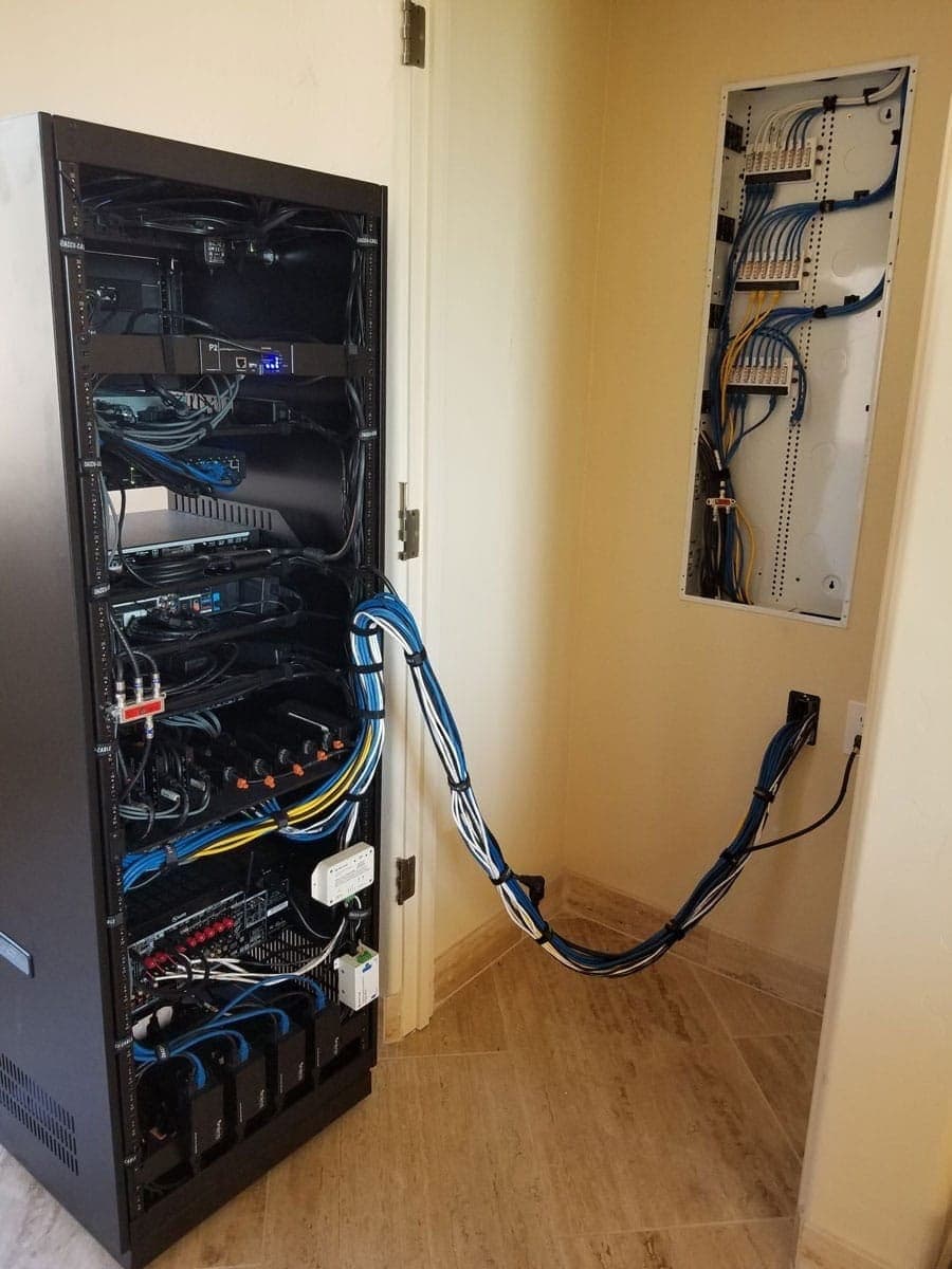 Network rack installed in a utility closet with patched cabling