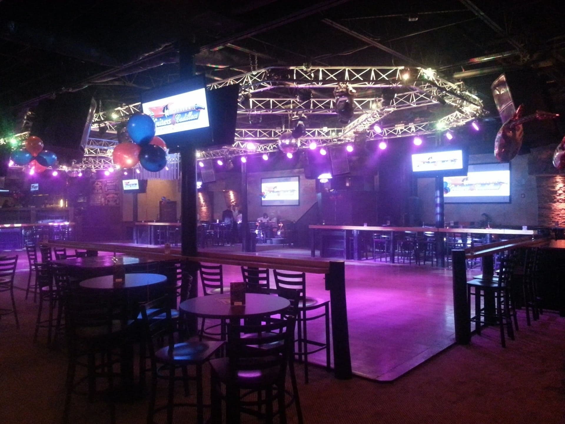 Tucson nightclub interior with magenta wash lighting and stage audio