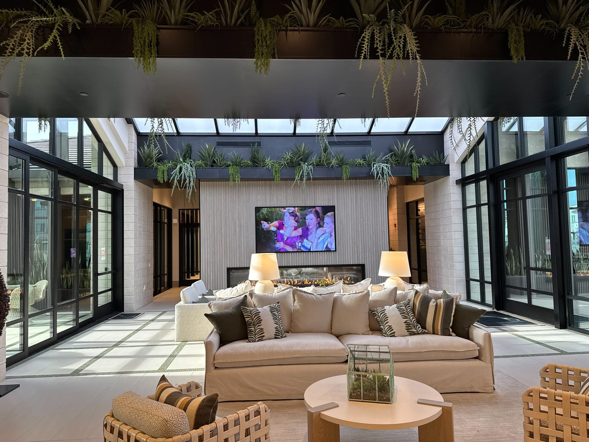 Open living room with floor-to-ceiling glass and a wall-mounted display